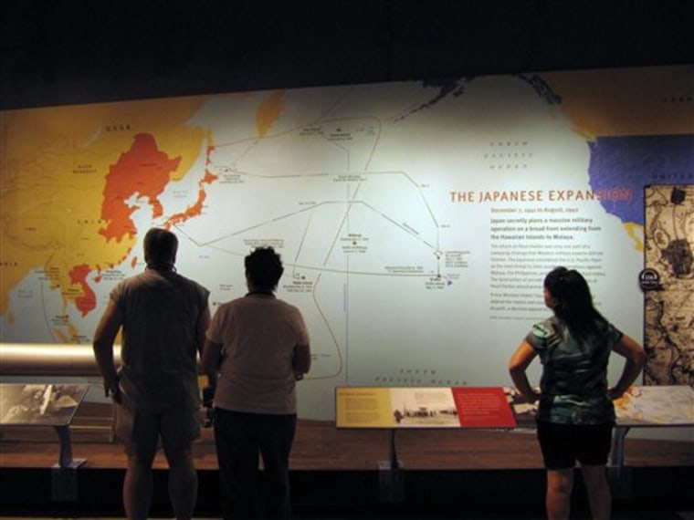 Visitors to the USS Arizona Memorial look at a display April 15 at Pearl Harbor, Hawaii. The new museum now includes snapshots of life in 1930s Japan — a significant departure from the old collection.